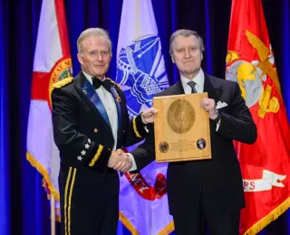 US Special Operations Command (USSOCOM) Commander General Tony Thomas presents Secretary William Cohen with a plaque commemorating his leadership in the creation of the US Special Operations Command in 1987.